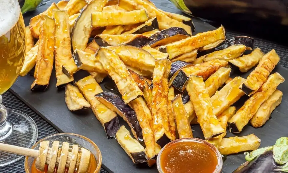 Golden fried aubergine slices drizzled with dark cane honey