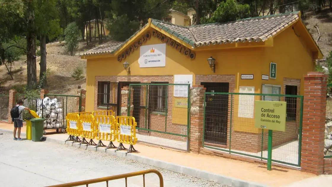 Hikers on the suspended walkway of Caminito del Rey with sheer gorge walls rising 700 metres above the Guadalhorce River