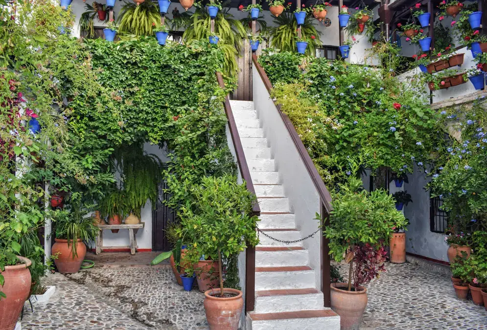 Traditional Córdoba patio with whitewashed walls, hanging geraniums and a central fountain