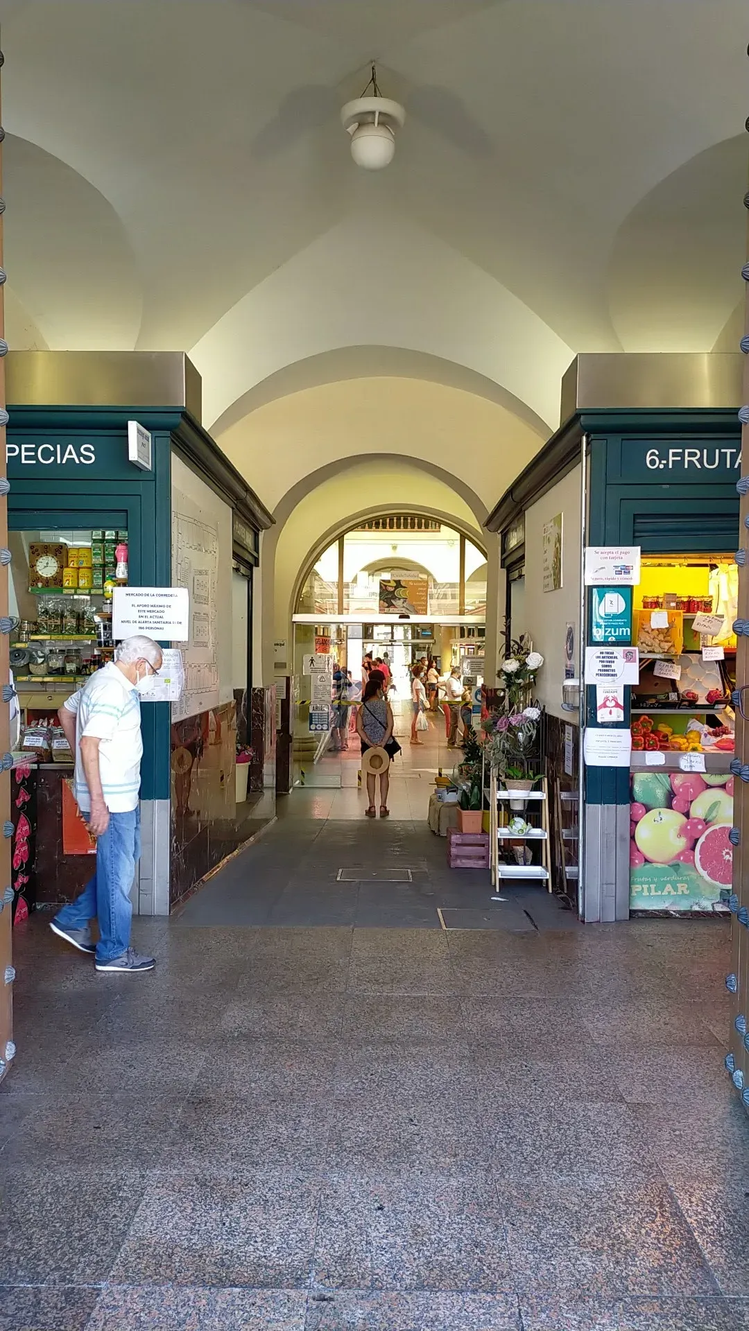 Entrance to Mercado de la Corredera through the 17th-century arcades with fruit stalls visible