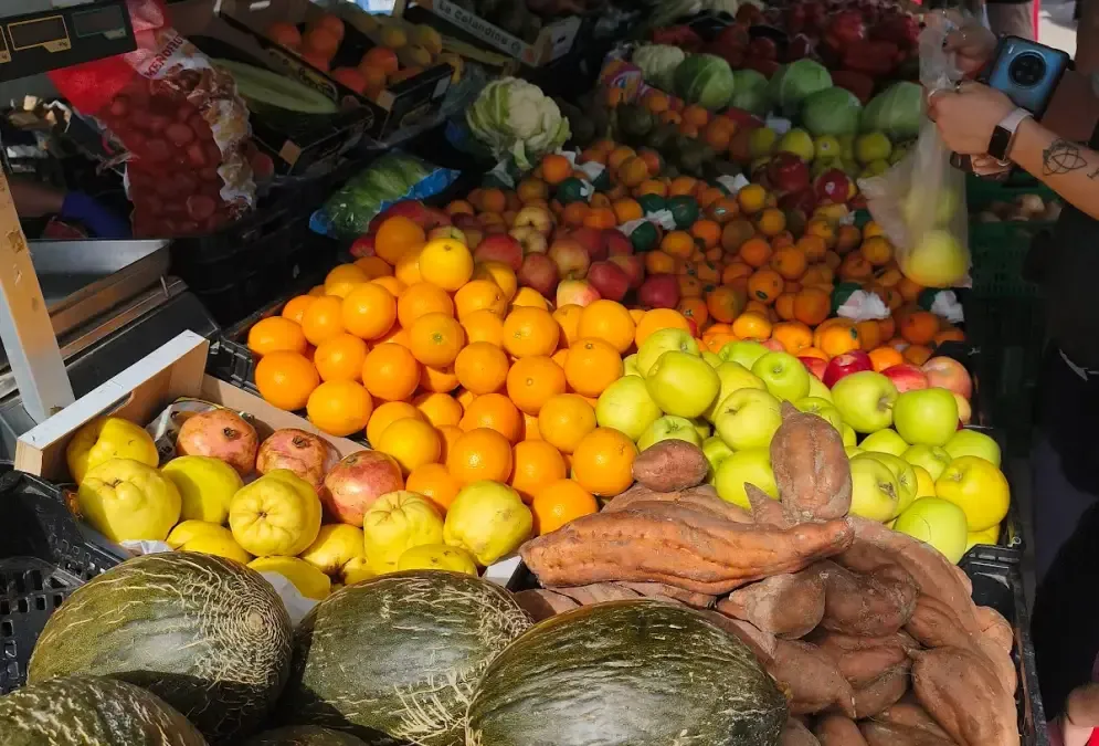 Outdoor market stalls at El Arenal Sunday market with fresh produce under canopies