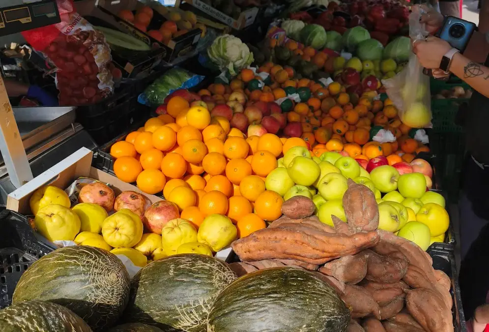 Outdoor market stalls at El Arenal Sunday market with fresh produce under canopies