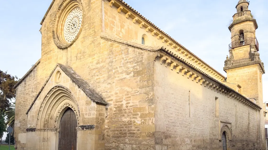 Exterior of the Iglesia de la Magdalena in Córdoba with its Mudéjar-Gothic stonework, pointed Epístola doorway framed by an alfiz and the academicist bell tower