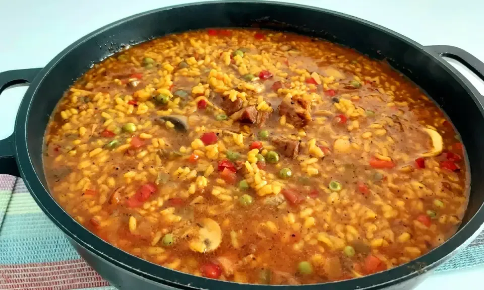 Large perol pan with rice dish cooking over open firewood fire in Córdoba countryside