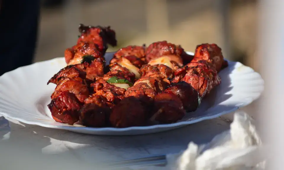 Grilled pinchos morunos skewers on a plate, caramelised and spiced, Córdoba style