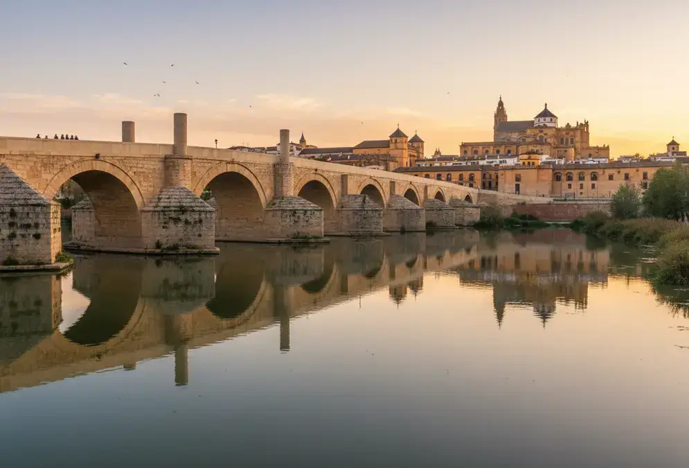 The Roman Bridge of Córdoba with the old city behind it, reflecting in the Guadalquivir at dawn