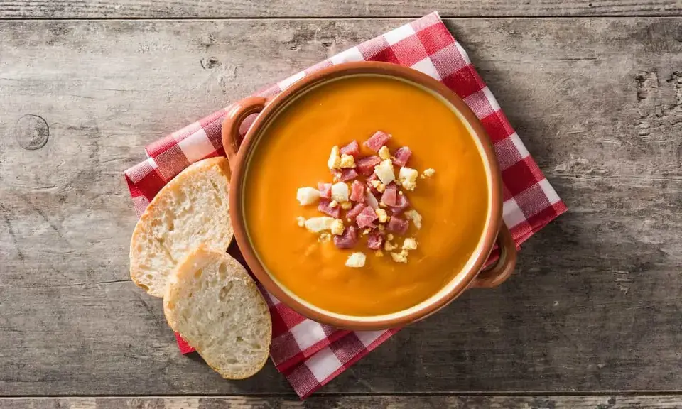 Bowl of Córdoba salmorejo — thick chilled tomato soup topped with hard-boiled egg and serrano ham