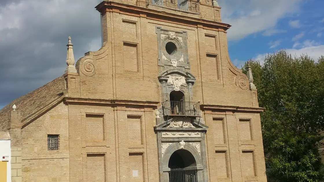Fuensanta Sanctuary in Córdoba, Spain, with its Baroque church and the Gothic humilladero fountain shrine in the forecourt in warm afternoon light