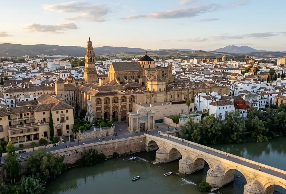 Spain travel statistics 2026 — aerial view of Córdoba's Mezquita-Catedral and Guadalquivir river at dusk